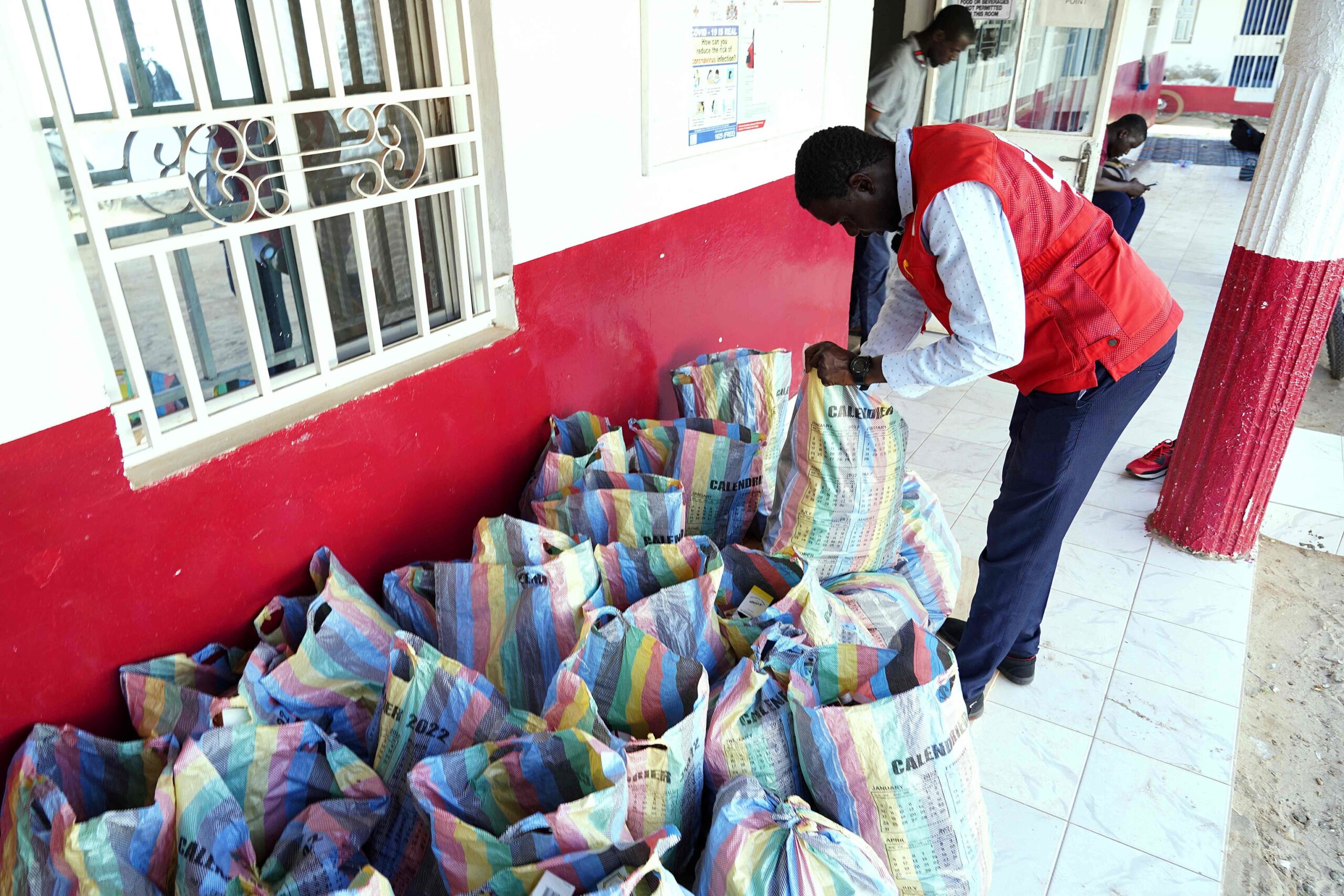 Un membre de la Croix-Rouge gambienne montre des sacs contenant les sirops retirés.