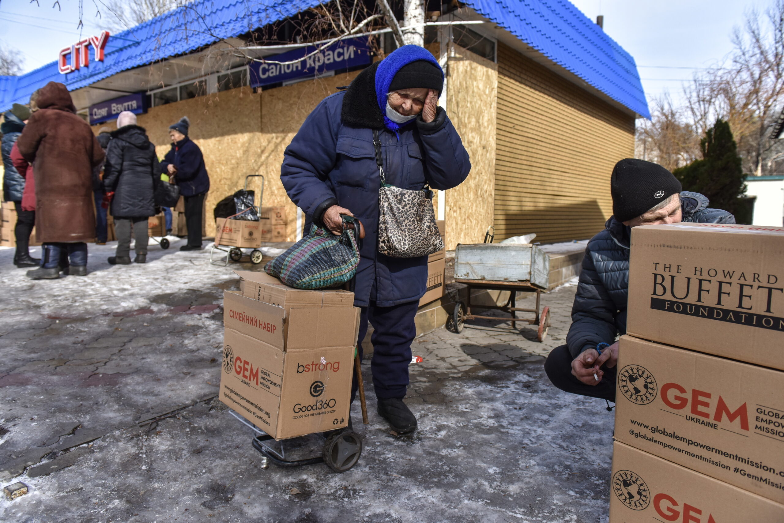 Plusieurs personnes recueillent des boîtes d'aide humanitaire dans le regi
