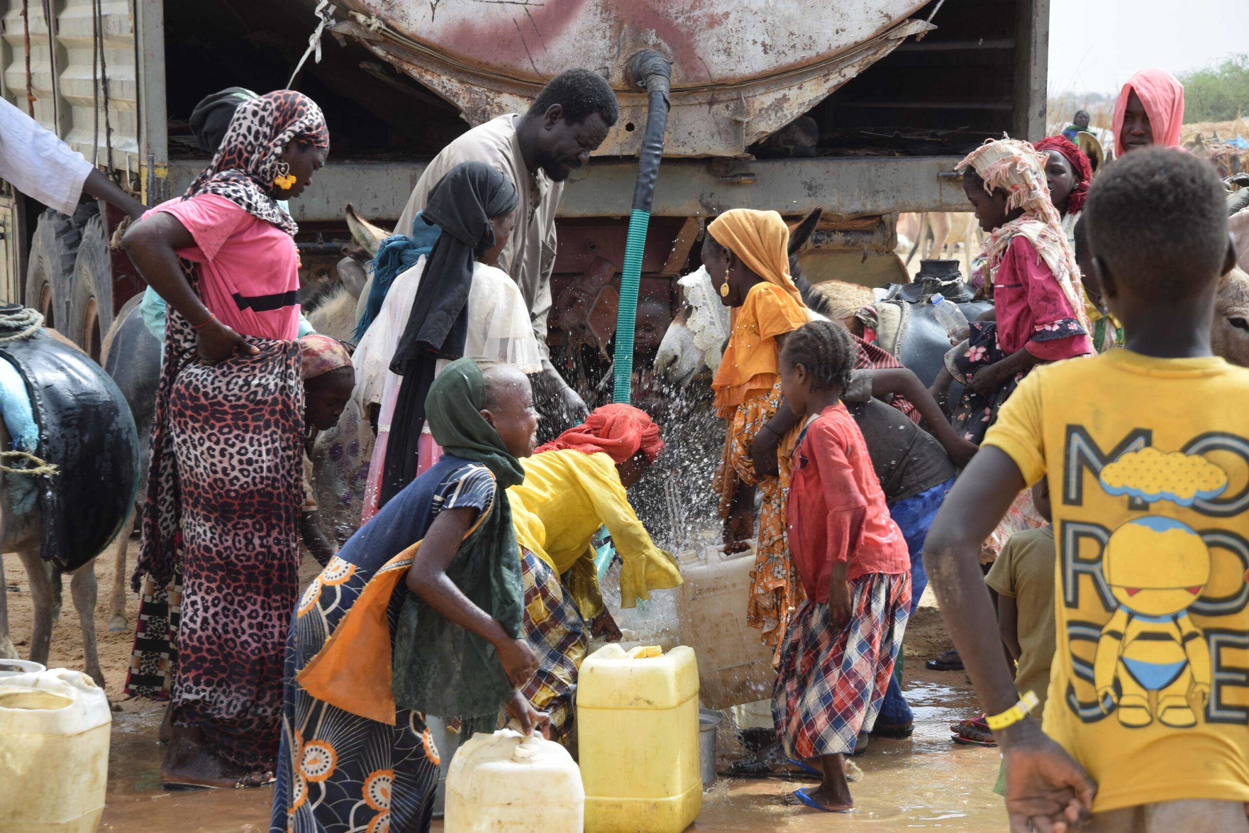 Des réfugiés soudanais remplissent des bidons d'eau potable ce dimanche à Koufroun, au Tchad.