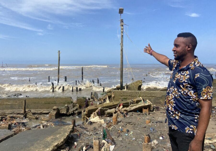 Akingboye Thompson pointe vers la gauche par les ravages de l'océan Atlantique.  Crédit : Abiodun Jamiu.