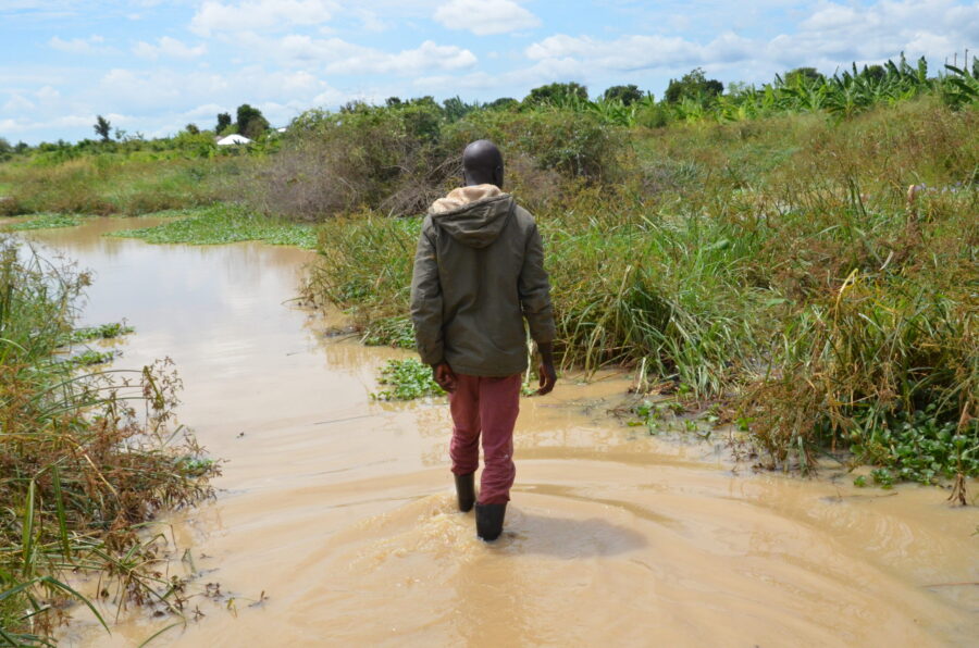 Un agriculteur patauge dans son jardin après que les inondations l'ont détruit dans le village de Kasenyi, dans la région d'Albertine, dans l'ouest de l'Ouganda.  Crédit : John Okot..