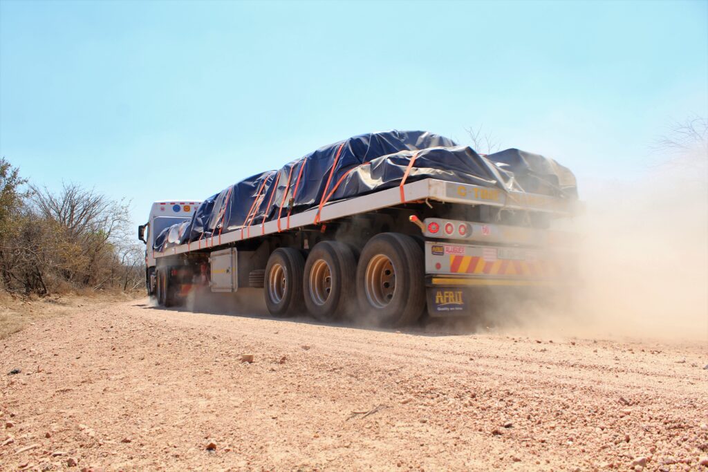 Un camion transportant du lithium du Zimbabwe au Mozambique soulève un nuage de poussière.  Crédit : Bernard Chiketo.