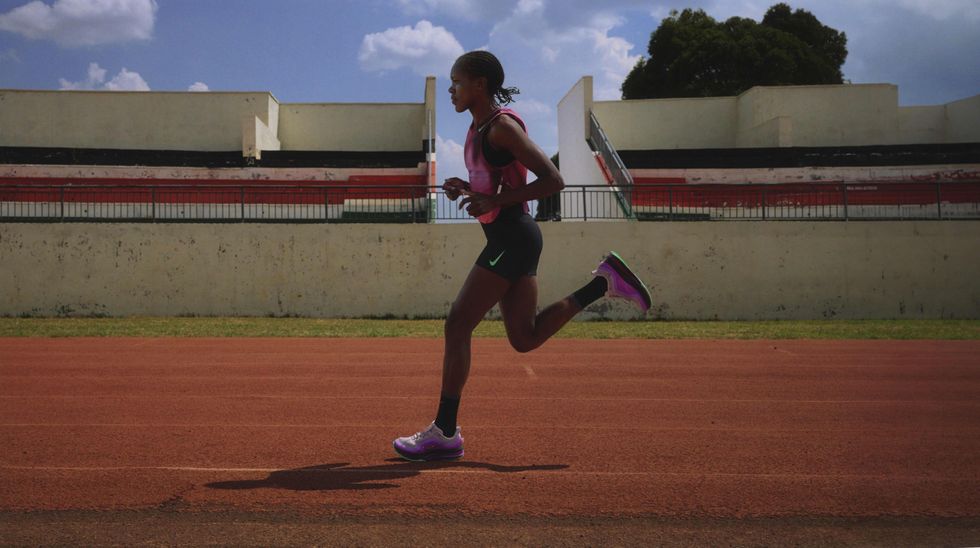 Faith Kipyegon court sur une piste portant la collection violette créée pour honorer sa tentative de moins de quatre milles.