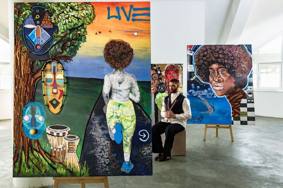 L'artiste Osoranna se trouve entre deux de ses œuvres.