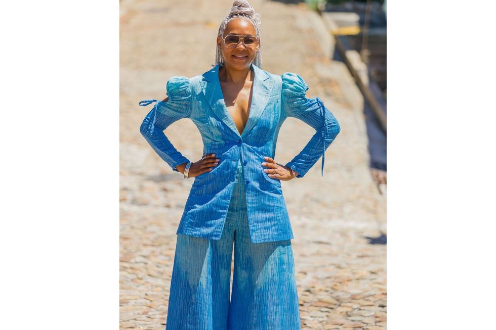 Un modèle pose dans une veste bleue et tie-dye et une paire de pantalons conçus par Kahindo Mateene pour sa marque de mode éponyme, Kahindo.