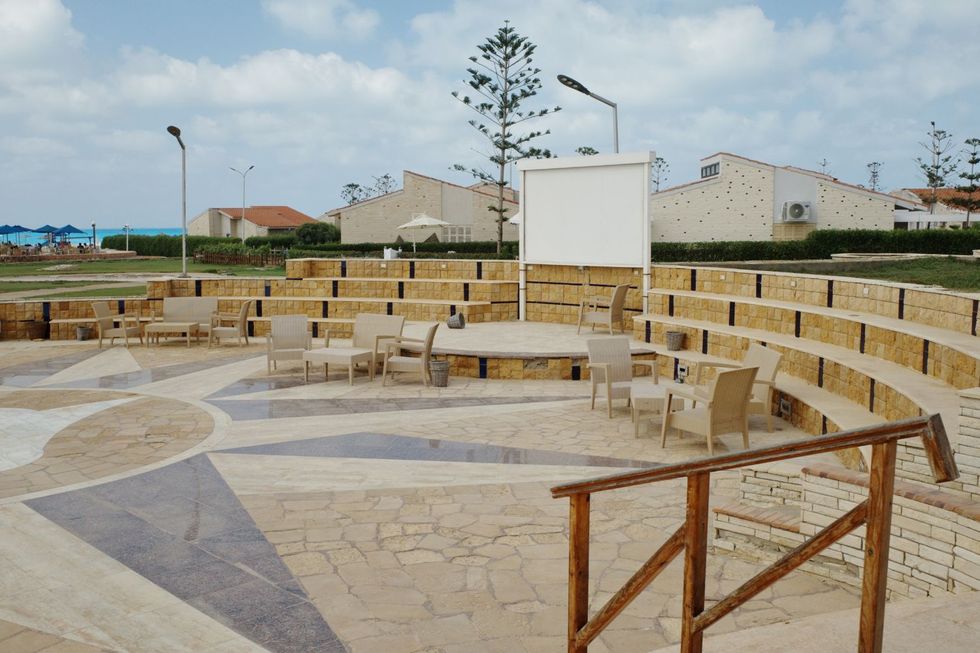 Un petit espace d'amphithéâtre avec des chaises désertes et un tableau blanc vide.