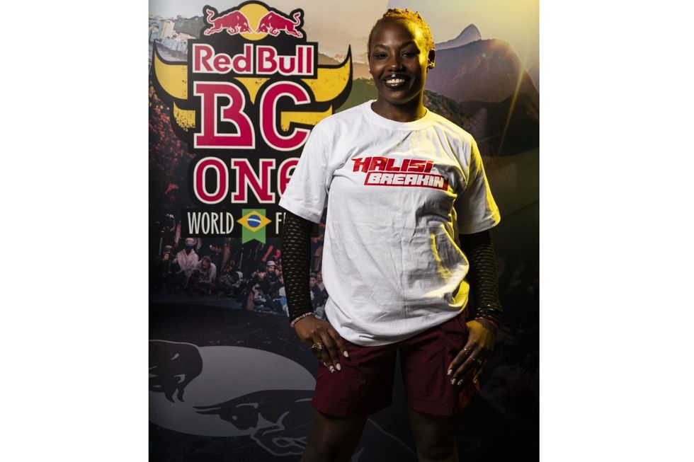 ACY Kare se tient en souriant devant le Red Bull BC One World Final Farp à Rio de Janeiro, portant une chemise Halisi Breakin.