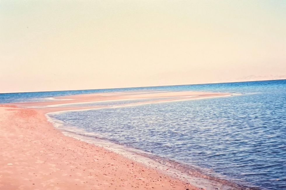 Une plage de la mer Rouge avec des sables oranges et des eaux bleues profondes.