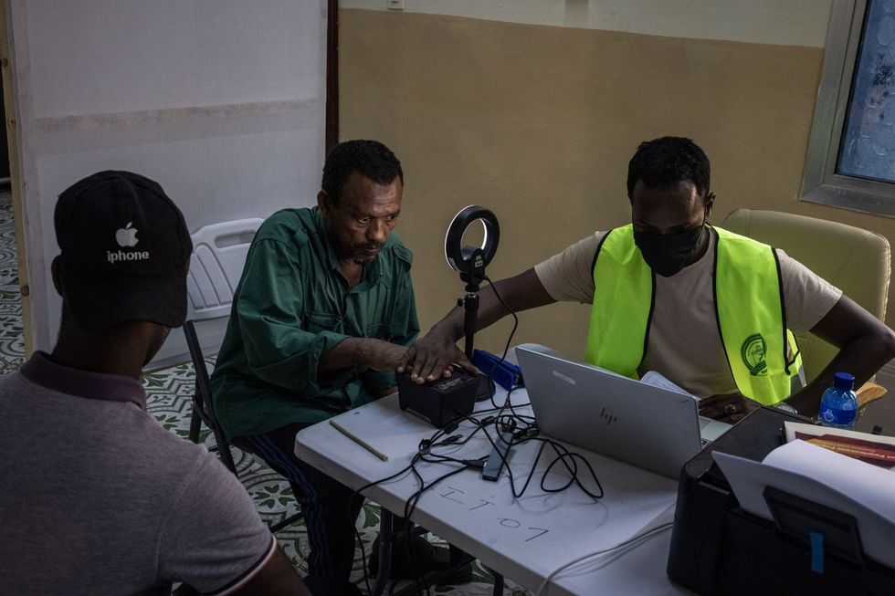 Un homme somalien a ses photos, ses empreintes digitales et ses détails alors qu'il s'inscrit pour voter lors d'un enregistrement de vote géré par des responsables de la Commission nationale des limites électorales le 23 avril 2025, à Mogadiscio, en Somalie.