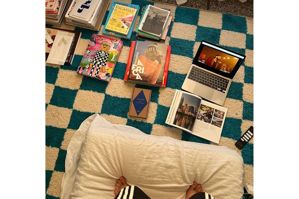 Plusieurs magazines de mode et de design sont disposés sur un tapis bleu et blanc.