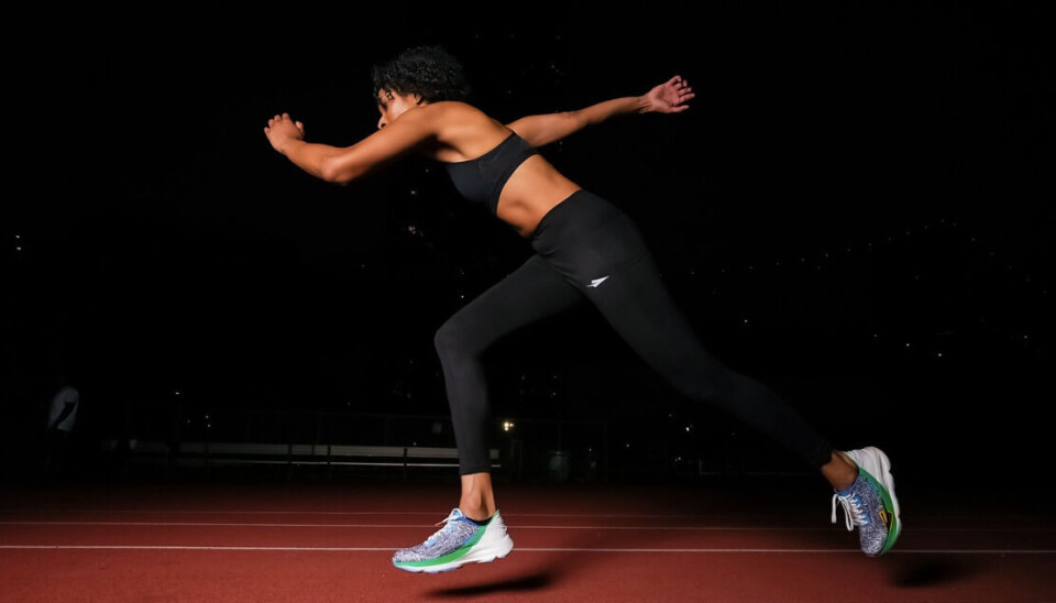 Enda Sportswear est la première marque africaine de chaussures de course performantes. Un coureur vêtu d’un soutien-gorge de sport noir et de leggings se lance dans un sprint.