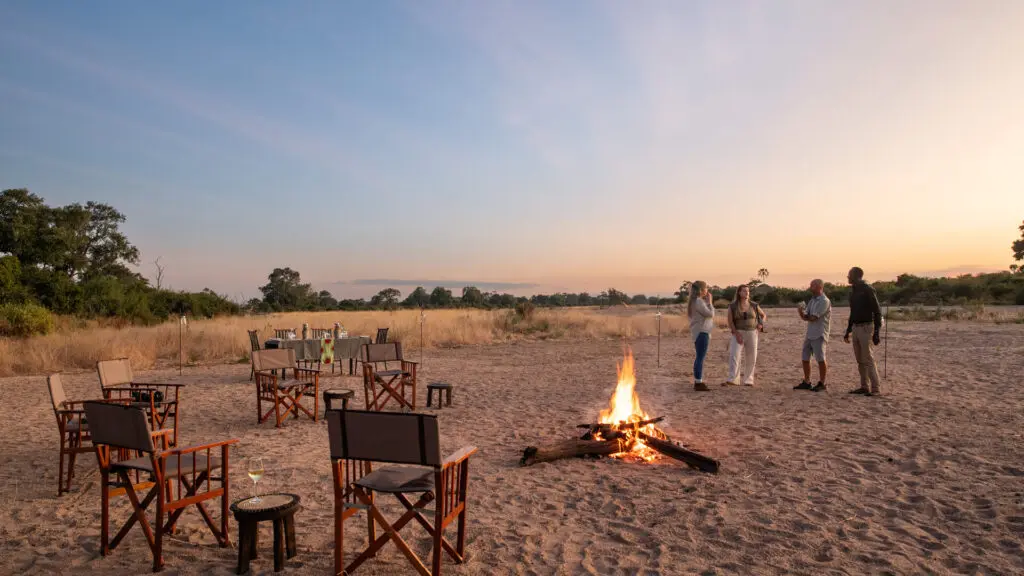 invités d'Asilia avec feu de camp au coucher du soleil