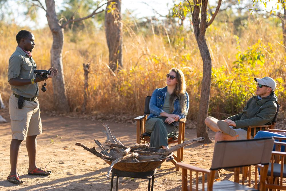 Un membre du personnel local interagit avec les invités au camp d'expédition d'Usangu, dans le parc national de Ruaha, en Tanzanie.