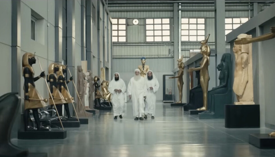 Trois hommes barbus portant un jalalib blanc et tenant des chapelets se promènent dans un musée rempli de statues égyptiennes antiques, contrastant fortement avec les statues égyptiennes antiques et l’« islamisme » extrême d’aujourd’hui.