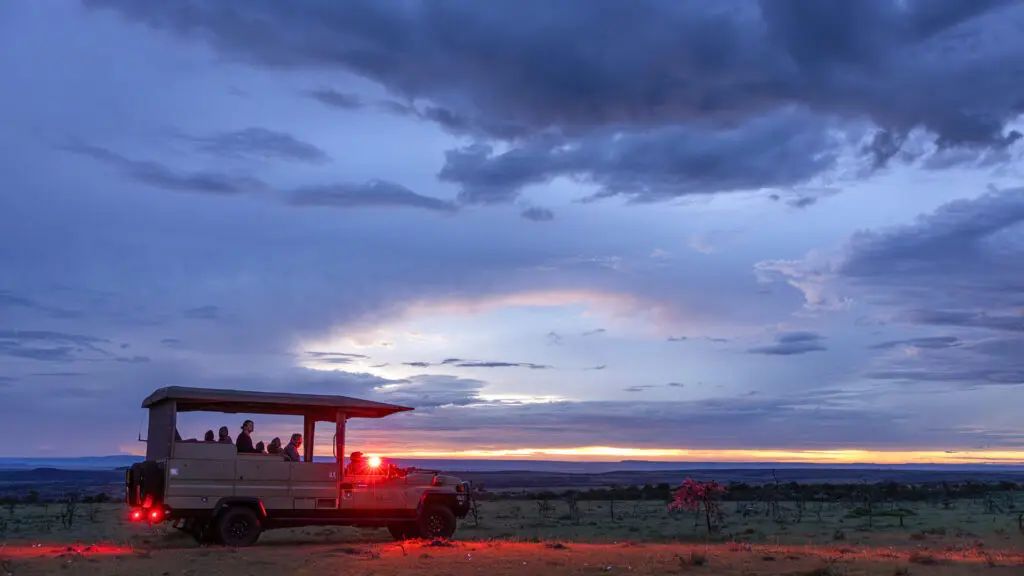 Véhicule de safari avec projecteur lors d'une promenade nocturne dans la réserve de Naboisho