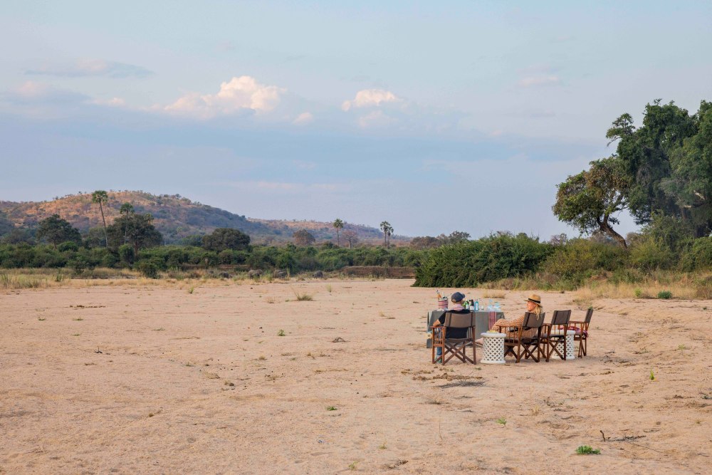 Les clients profitent d'un apéritif dans le lit d'une rivière asséchée dans le parc national de Ruaha, en Tanzanie.