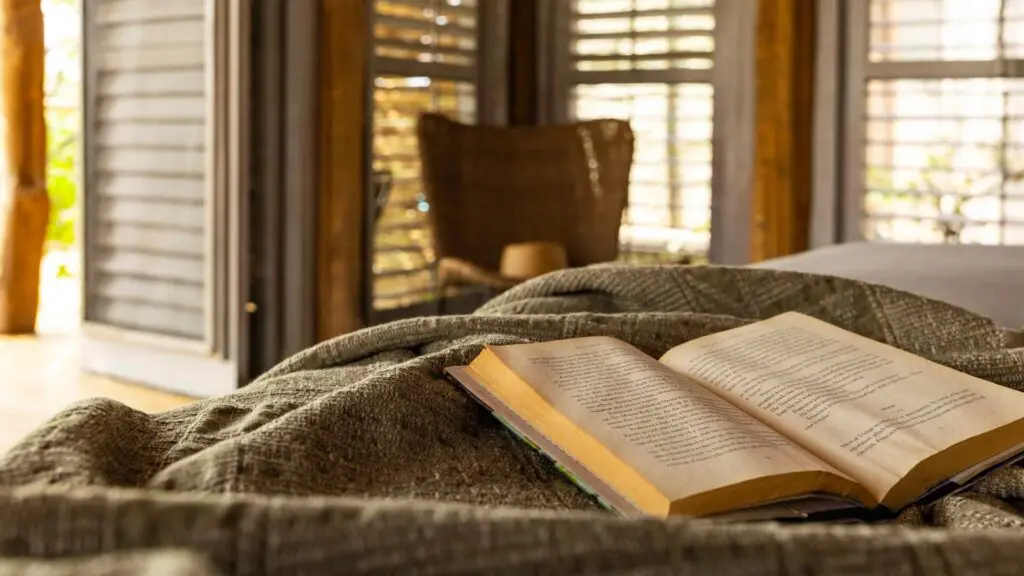 Un livre repose ouvert sur un lit dans une suite safari de luxe