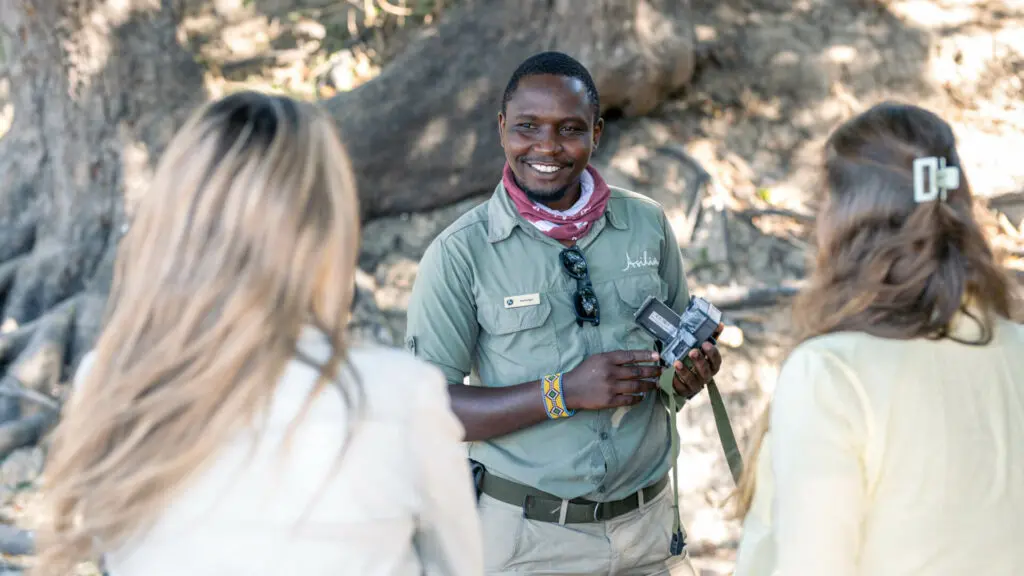 Un guide souriant explique aux invités les pièges photographiques et leurs utilisations en matière de conservation.
