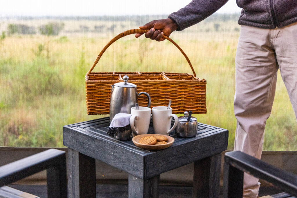 Personnel du camp de migration d'Olakira en Tanzanie livrant du café aux tentes des invités. 
