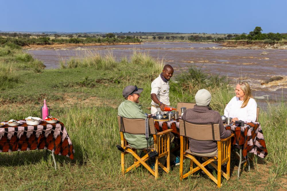 Les clients profitent d'un petit-déjeuner cuisiné au bord de la rivière Mara, en Tanzanie.