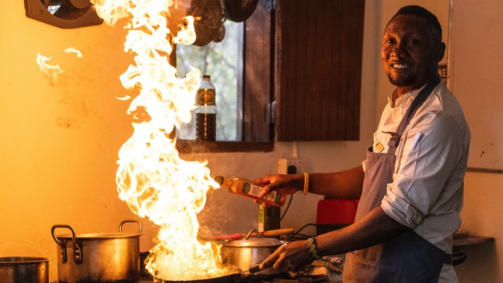 Chef cuisinant avec le feu, Rubondo Island, Tanzanie.