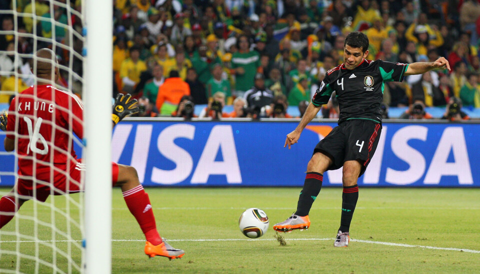 Le Mexicain Rafael Marquez tire vers le but tandis que le gardien sud-africain plonge lors d'un match de Coupe du monde.