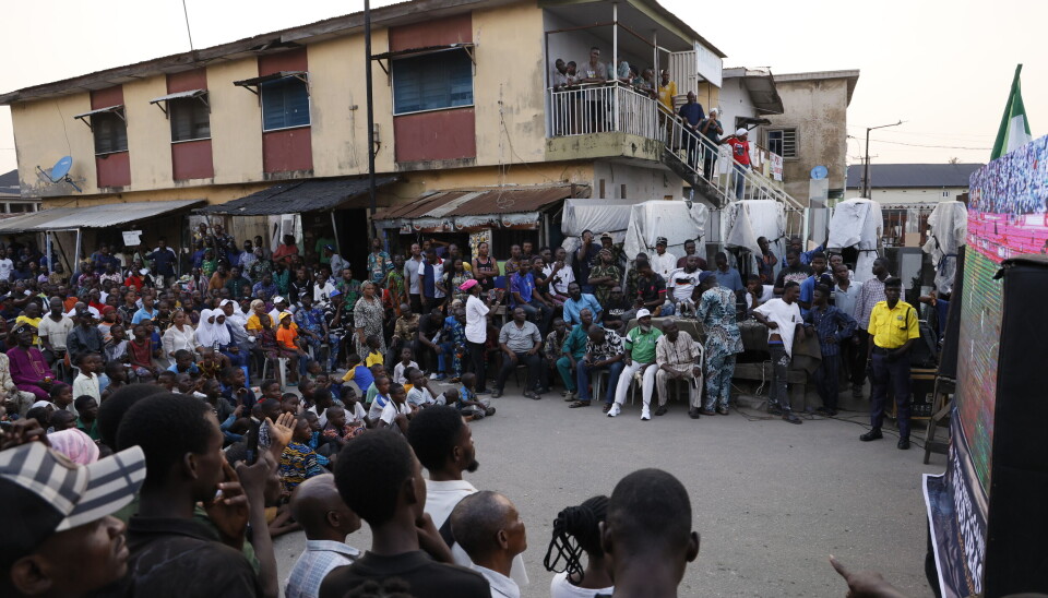 Une grande foule de fans de football regarde un quart de finale de la CAN sur un écran extérieur à Lagos.