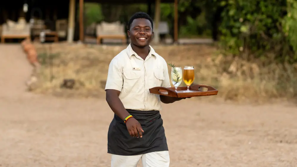 Un serveur avec des boissons, Kokoko Camp, parc national de Ruaha, Tanzanie.